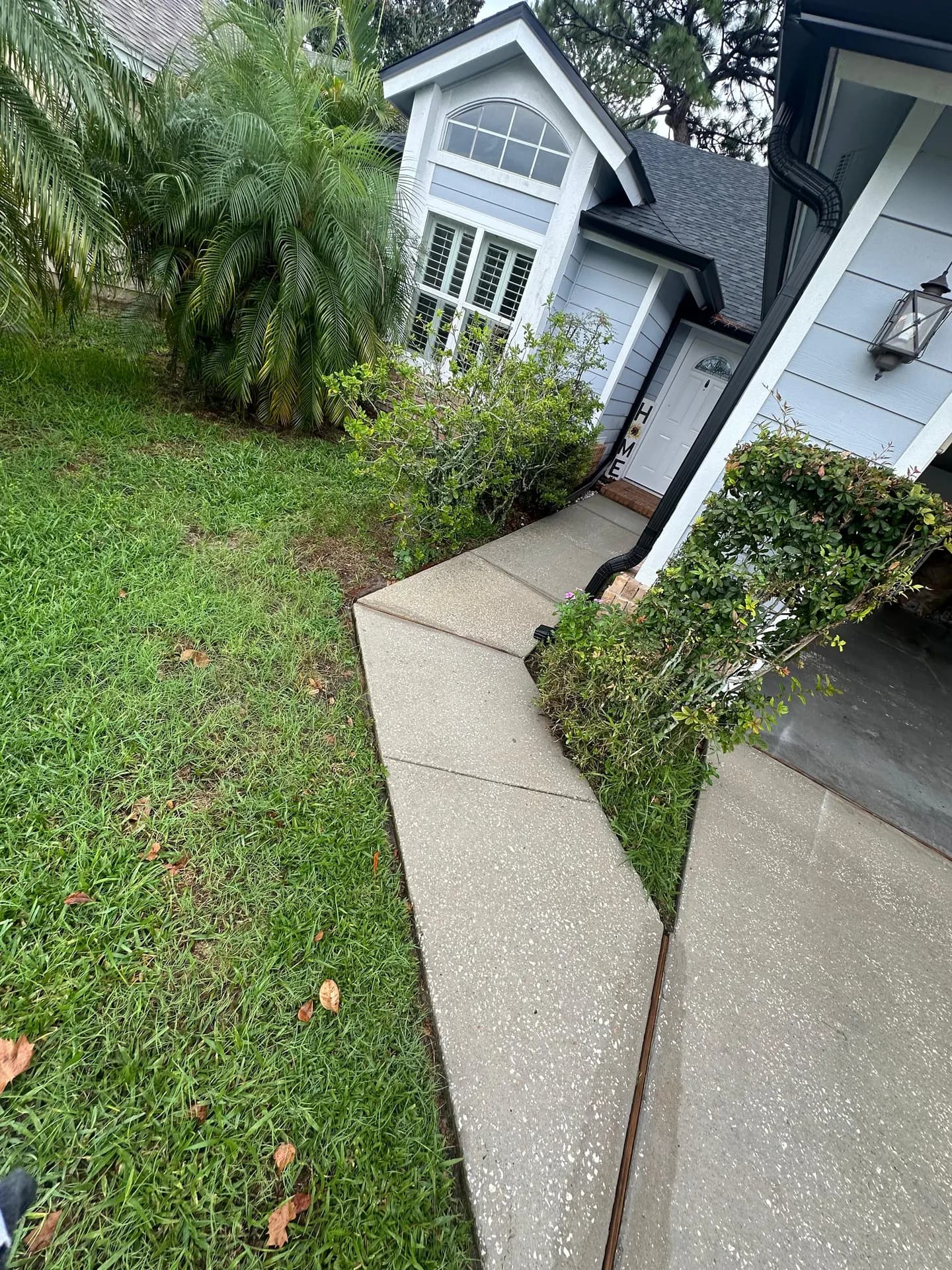 Black gutter and downspout on a blue Florida home after cleaning